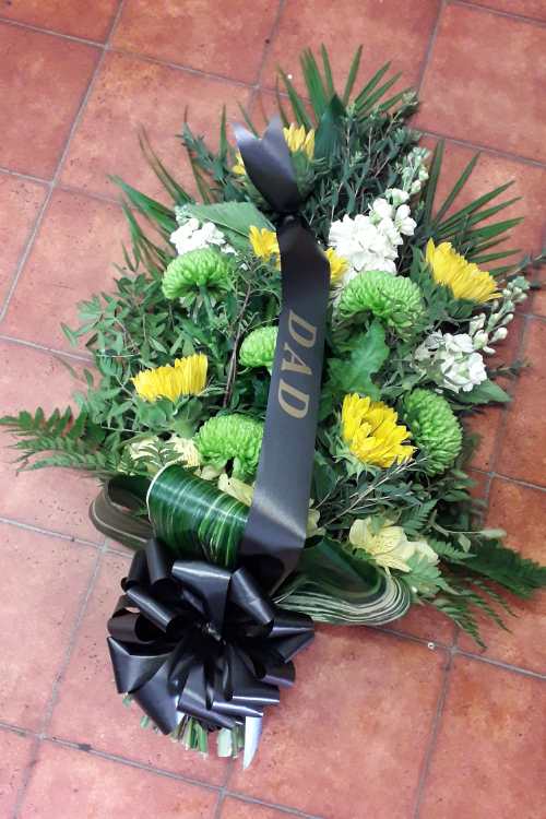 This tied sheaf has Sunflowers, Stocks, acid green Chrysanthemums and mixed foliage, tied with black bow and sash with lettering.
