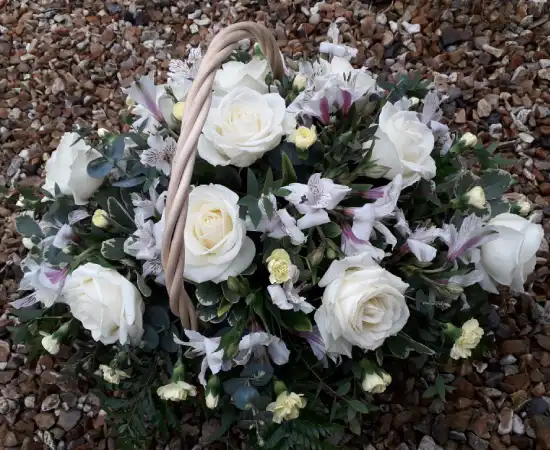Beautiful gift basket with white Roses, white Alstroemeria, spray Carnations and complimentary foliage.
