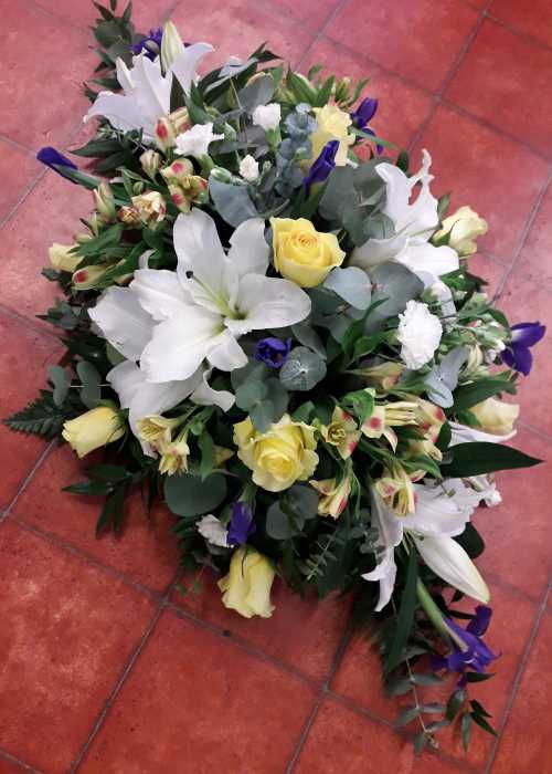 Double ended coffin spray with White Lilies, Yellow Roses, Blue Iris, Yellow Alstroemeria and complimentary foliage's
