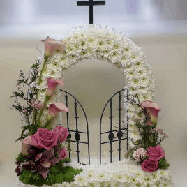 A Gates of Heaven funeral tribute is a stunning and meaningful floral arrangement that symbolizes the passage of a loved one into eternal rest. Designed to reflect the grandeur of a heavenly entrance, this tribute brings comfort and solace to grieving families while celebrating the life of the departed. The Meaning Behind the Gates of Heaven Tribute This elegant arrangement typically features a pair of floral-adorned gates, often accompanied by angelic accents or cascading flowers. It represents a peaceful transition, offering reassurance that the loved one is welcomed into a place of eternal serenity.